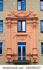 Balcony With Columns On Facade Of Old Residential Building Decorated With Bas-reliefs. Stalinist Architecture, Stalin Empire Style. Balcony And Windows Of Soviet Building
