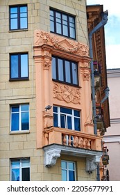 Balcony With Columns On Facade Of Old Residential Building Decorated With Bas-reliefs. Stalinist Architecture, Stalin Empire Style. Balcony And Windows Of Soviet Building
