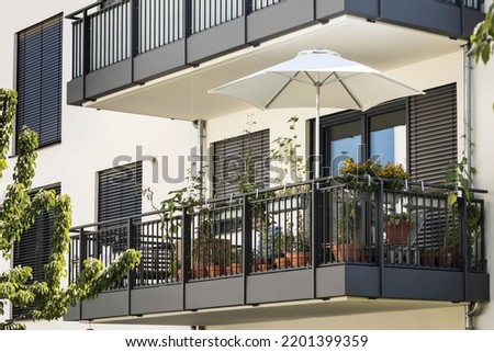 Balcony with Flowers for relax, Facade view. Decorated Modern Balcony Garden of Residential House with Shutters Windows.