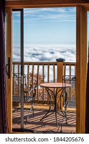 Balcony Terrace Outside In Wintergreen, Virginia With Blue Ridge Mountain View And Cloud Inversion With Blue Sky And Sunlight On Chairs Table Railing