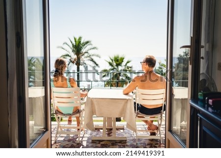 Balcony or terrace in a sea view room in hotel resort or villa. Couple on vacation. Luxury summer holiday on exotic tropical island or Mediterranean city. People enjoying relaxing family getaway.