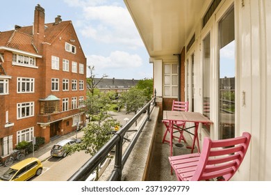 a balcony with two pink chairs and a yellow car parked on the sidewalk in front of the building is red - Powered by Shutterstock