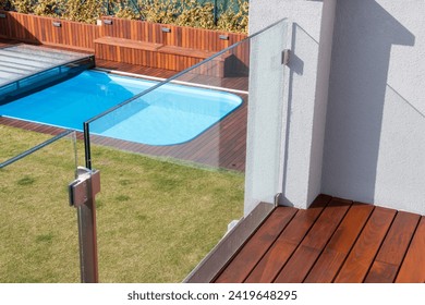 Balcony wood floor with glass railing fence view to garden deck pool - Powered by Shutterstock