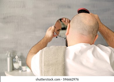 Bald Adult Man With Hair Brush Looking In Mirror At Home