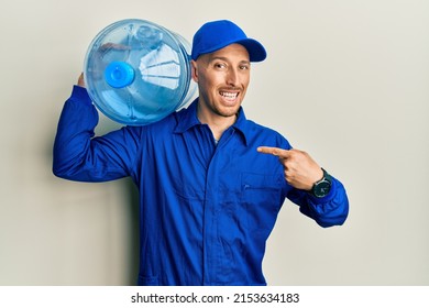 Bald Courier Man With Beard Holding A Gallon Bottle Of Water For Delivery Pointing Finger To One Self Smiling Happy And Proud 