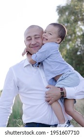 Bald Dad And Little Son In The Field Or Forest On Sunny Summer Day. Father's Day.