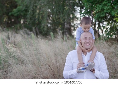 Bald Dad And Little Son In The Field Or Forest On Sunny Summer Day. Father's Day.