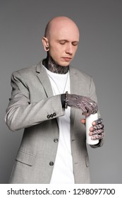 Bald Handsome Tattooed Man In Suit Jacket Opening Aluminum Can Isolated On Grey