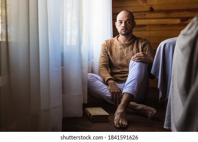 Bald Man With A Beard Reading A Book With A Sweater For The Cold