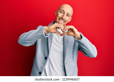 Bald Man With Beard Wearing Business Jacket Smiling In Love Doing Heart Symbol Shape With Hands. Romantic Concept. 