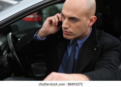 Bald Man With Mobile Telephone Getting Into Car