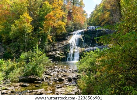 Bald River Falls, Tellico Plains, TN. Ribbons of water cascading over rocks and surrounded by rich autumn foliage. Below the falls is a rocky riverbed. Accessed off the Cherohala Skyway. 