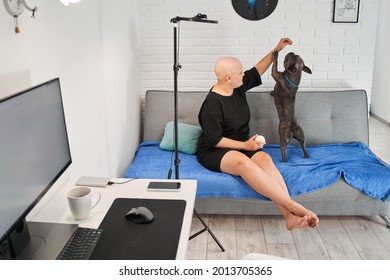 Bald Woman Playing With Her Active French Bulldog