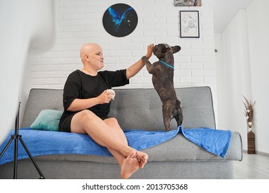 Bald Woman Playing With Her Active French Bulldog