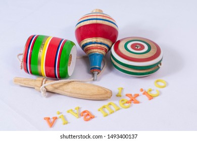 Balero, spin and yoyo, colorful wooden mexican toys and Viva Mexico made from colorful letters on white background