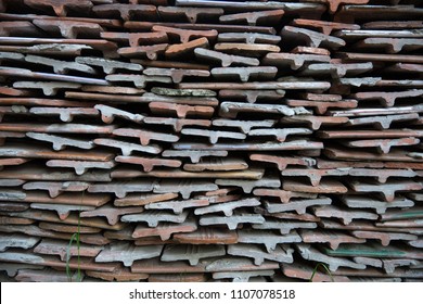 Bales ceramic shingles for roofing. Stack of old ceramic roof tiles, textured background.