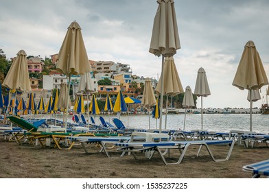 Bali, Crete, Greece - 10.09.2019: Inclement Weather At The Resort. Empty Beach, Sun Loungers And Covered Umbrellas.