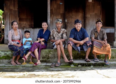 Bali, Indonesia, April 11th 2019. Balinese Family Sit In Front Of Old Balinese House From Bamboo.