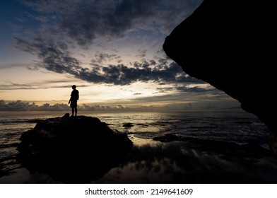 BALI, INDONESIA - April 2022: Man's silhouette on the stone near the Tanah Lot temple in Bali, Indonesia