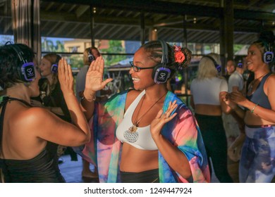 Bali, Indonesia - December 1, 2018: Two Girls About To High Five With Headphones On During Silent Disco Dance