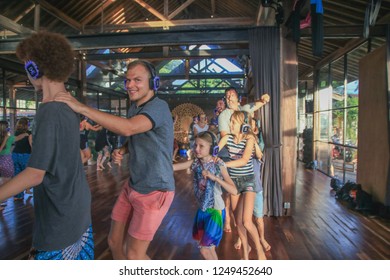 Bali, Indonesia - December 1, 2018: Group Of People In A Conga Line Dancing With Headphones On