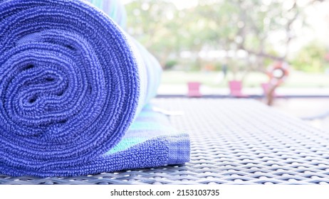 Bali, Indonesia, February 1, 2022. Rolled towels at the edge of the pool used to dry the body after swimming. Towel is a piece of cloth or paper that can absorb liquid and is used to wipe or dry.