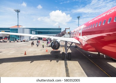 BALI, INDONESIA - FEBRUARY 14, 2017: Travelers Exit An Airasia Plane On The Tarmac Of Denpasar Airport In Bali Island, The Main Travel Destination In Indonesia.