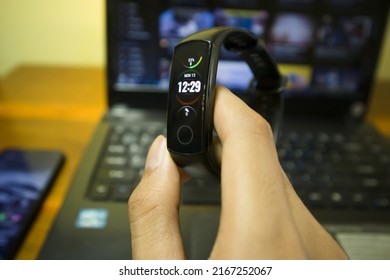 BALI, INDONESIA JUNE 09 2022 : A Man Using And Touch Screen Honor Band 5 Smartwatch That Huawei Manufactured