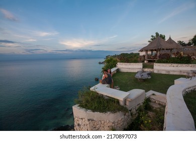 BALI, INDONESIA - MAY 30: Unidentified tourist visit resort located on cliff side over the Indian Ocean in Uluwatu, The swimming pool against a panorama of sunset at the ocean on May 30, 2015