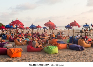 BALI, INDONESIA - OCTOBER 31, 2015: Tourists enjoy a drink while waiting for the sunset in a beach bar along Seminyak beach, just north of Kuta, in Bali.