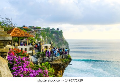 Bali, INDONESIA - September 25, 2018: Tourists stand at sunset and admire the scenery on a cliff near the Uluwatu Temple on the island of Bali, Indonesia