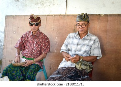 Bali, Indonesia, September 4, 2019. Two Balinese Man, Enjoying Food During A Wedding Ceremony.