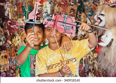 BALI ISLAND, INDONESIA - JULY 11, 2015: Smiley Balinese Children Have Fun And Play With Characters Of Traditional Shadow Puppets - Wayang Kulit. Arts, Crafts And Culture Festivals Of Indonesian People