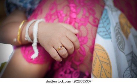 Bali Island, Indonesia, November 9, 2016: A Child's Hand Wearing Gold Bracelet And Two Thick White Yarn Bracelets, And A Gold Ring On His Finger. He Just Finished His Balinese Traditional Birthday.