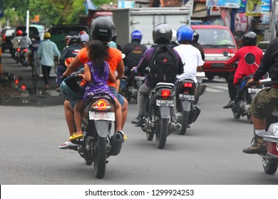 Bali. January 2019. Dangerous Riding A Motorcycle. Transportation Of Children Without A Helmet. A Girl Rides With Her Mother On Motorbike