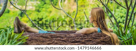 Bali trend, straw nests everywhere. Young tourist enjoying her travel around Bali island, Indonesia. Making a stop on a beautiful hill. Photo in a straw nest, natural environment. Lifestyle BANNER