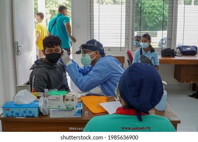 BALIINDONESIA-MAY 28 2021: An ENT doctor is examining the ears, nose and throat of a pediatric patient. During the COVID-19 pandemic, ENT examinations are very risky 