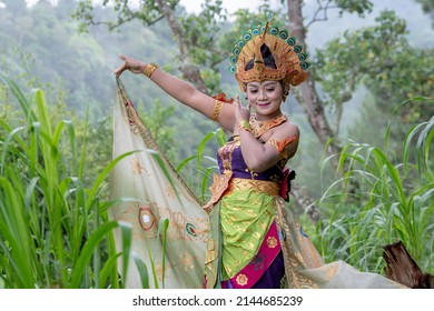 Balinese Dancer Woman Outdoors With Colorful Bird Costume In Rainforest