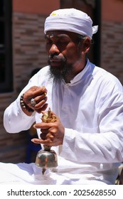 Balinese Hindu priest holding the bell while leading the prayer.