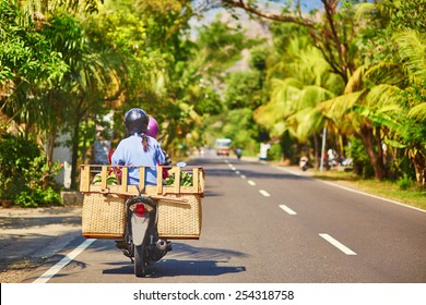 Balinese man with huge luggage on scooter