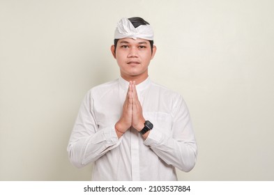 Balinese man wearing traditional clothes with welcome hands gesture - Shutterstock ID 2103537884
