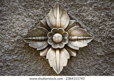 Balinese stone carved flower pattern background on cement wall
