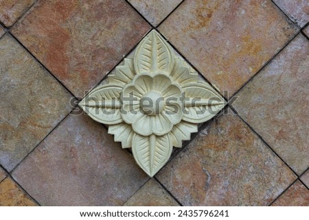 Balinese stone carved flower pattern background on granite stone wall
