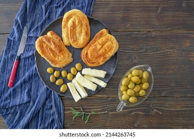 Balkan cuisine. Burek, filled pastry, popular national dish in Balkans. Olives and local soft white cheese. Rustic table, copy space