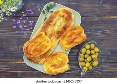 Balkan cuisine. Burek, filled pastry - popular national dish. Dark rustic table, free space for text