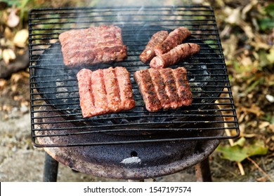 Balkan cuisine Pork Cevapi, grilled minced meat, on the improvised grill