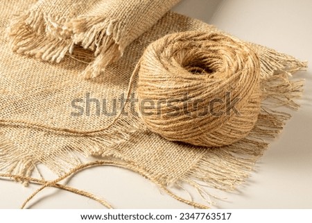 A ball of coarse textured jute threads on a burlap napkin