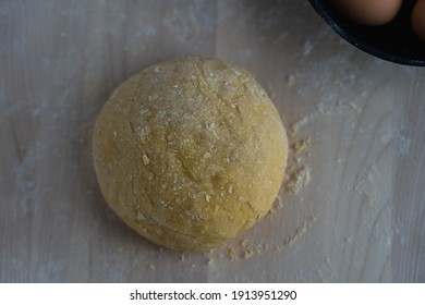 A ball of dough next to a bowl of eggs on a wooden surface - Powered by Shutterstock