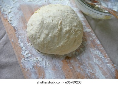 Ball Of Dough On A Cutting Board With Napkin And Mixing Bowl