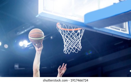 Ball in hoop at basketball game. Athletic competitions and games concept.